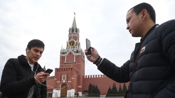 Молодые люди фотографируются на Красной площади у Московского Кремля - Sputnik Молдова