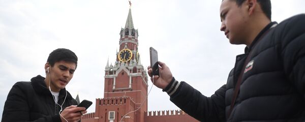 Молодые люди фотографируются на Красной площади у Московского Кремля - Sputnik Молдова