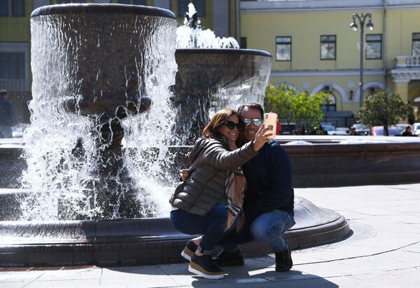 Отдыхающие фотографируются у фонтана на Театральной площади в Москве - Sputnik Молдова