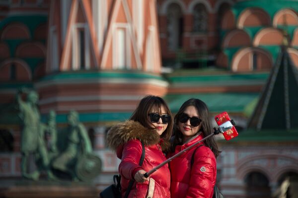 Девушки делают селфи на фоне храма Василия Блаженного в Москве - Sputnik Молдова