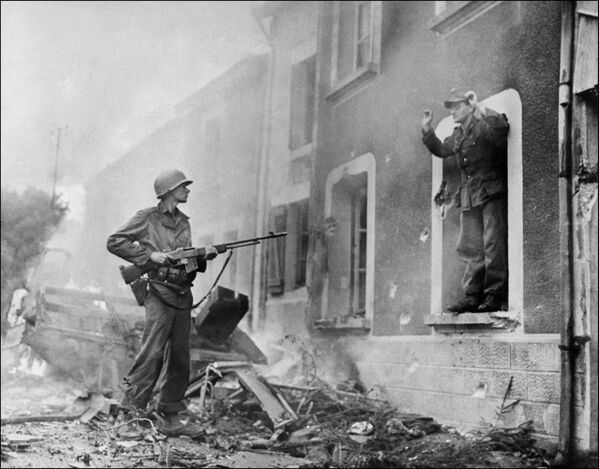 Un soldat american țintește cu arma un soldat neamț în luptele de eliberare a Franței în timpul celui de Al Doilea Război Mondial - Sputnik Moldova
