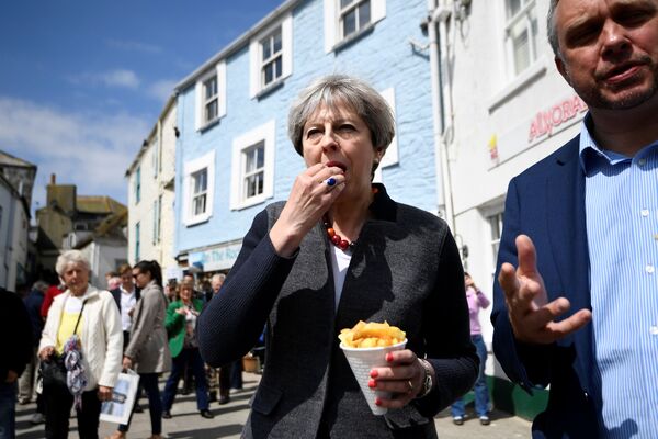 Премьер-министр Великобритании Тереза Мэй ест чипсы во время встречи с жителями Меваджиси, Великобритания - Sputnik Moldova-România