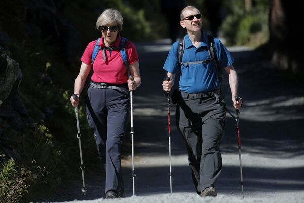 Премьер-министр Великобритании Тереза Мэй гуляет в лесу со своим мужем Филиппом в Альпах в Швейцарии - Sputnik Moldova-România