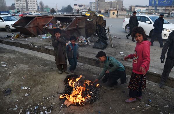 Афганские дети жгут пластик, чтобы согреться у костра на обочине дороги в Кабуле - Sputnik Молдова