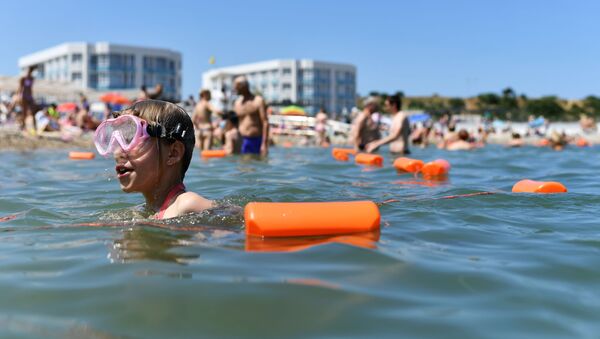 Отдыхающие купаются в Черном море возле пляжа Солдатский в Севастополе в Крыму - Sputnik Moldova