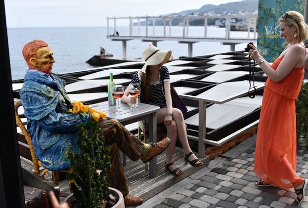 Девушки фотографируются со скульптурой Ван Гога на Массандровском пляже в Ялте в Крыму - Sputnik Moldova-România