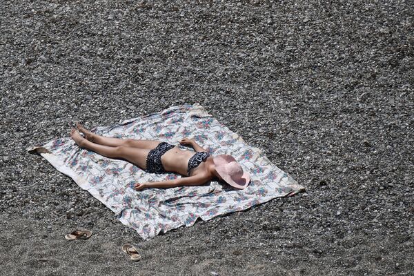 Девушка загорает на пляже возле мыса Меганом в Крыму - Sputnik Moldova-România