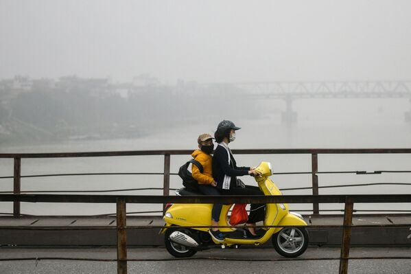 Женщина с ребенком в масках для лица едут по мосту среди смога над Ханоем - Sputnik Молдова