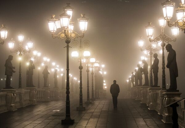 Мужчина идет по мосту через густой туман и смог в Скопье вечером 22 декабря 2018 года - Sputnik Молдова