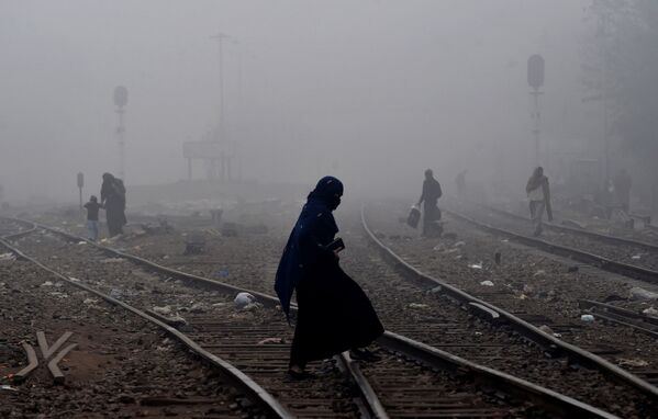Пакистанская женщина идет по густому туману через железнодорожные пути - Sputnik Молдова