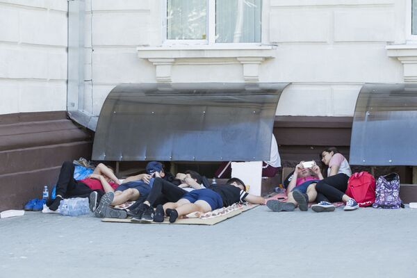 Протестующая молодежь прячется от солнца в тени здания Генпрокуратуры.  - Sputnik Молдова