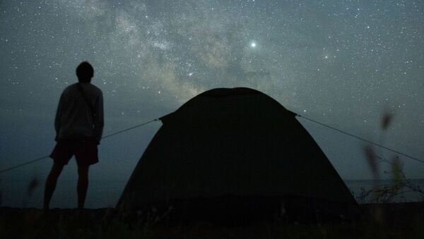 Мужчина наблюдает за звездным небом на берегу Черного моря возле поселка Морское в Крыму - Sputnik Молдова