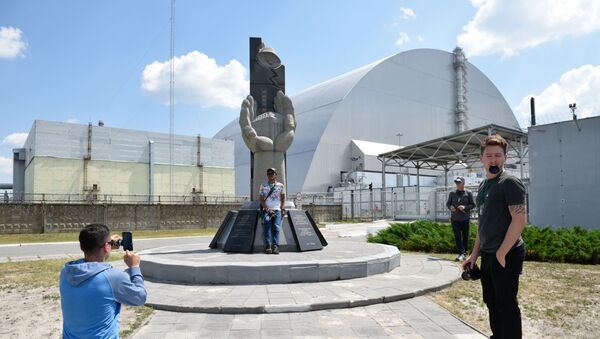 Туристы фотографируются возле памятника ликвидаторам аварии на Чернобыльской атомной электростанции имени Владимира Ильича Ленина  во время экскурсии в зону отчуждения в городе Чернобыль - Sputnik Moldova-România
