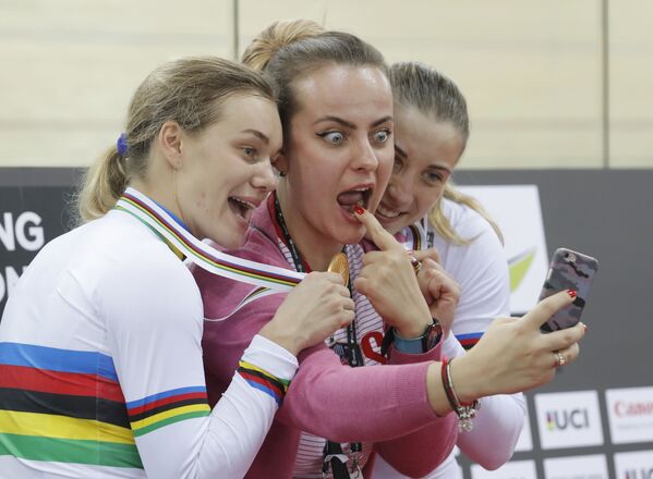 Российские спортсменки Анастасия Войнова и Дарья Шмелева позируют для селфи с неизвестной девушкой, завоевав золотую медаль в командном спринте среди женщин на чемпионате мира по велоспорту в Гонконге - Sputnik Молдова