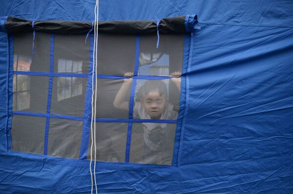 Ребенок во временном лагере для жертв землетрясения в городе Yibin, китайской провинции Сычуань  - Sputnik Moldova-România