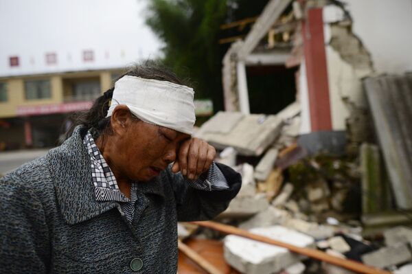 Раненая женщина плачет среди развалин домов после сильного землетрясения в городе Yibin китайской провинции Сычуань - Sputnik Moldova-România