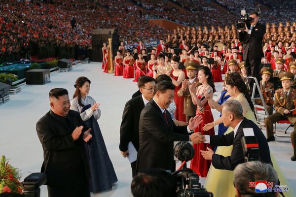 Северокорейский лидер Ким Чен Ын с женой и президент Китая Си Цзиньпин здороваются с гостями и участниками праздничного представления в честь визита Си Цзиньпина в Пхеньян  - Sputnik Moldova-România