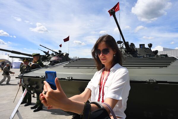 Посетительница фотографируется у боевой машины пехоты БМП-2 на Международном военно-техническом форуме Армия-2019 - Sputnik Moldova-România