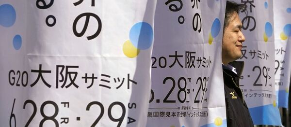 Мужчина с флагами с символикой саммита G20 в Осаке в Международном выставочном центре, Япония Мужчина с флагами с символикой саммита G20 в Осаке в Международном выставочном центре, Япония - Sputnik Молдова