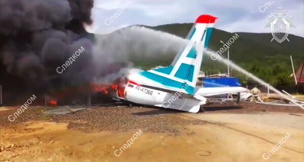Сотрудники противопожарной службы тушат пожар на месте аварийной посадки самолета Ан-24 в Нижнеангарске - Sputnik Moldova-România