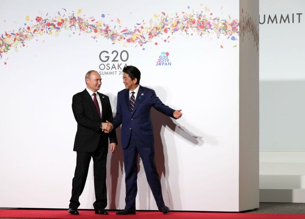Președintele Rusiei, Vladimir Putin, și premierul Japoniei, Shinzo Abe, la ceremonia întâmpinării oficiale a participanților la summitul G20 la centrul internațional expoziționale INTEX Osaka. - Sputnik Moldova