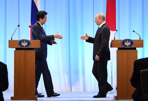 Președintele rus Vladimir Putin și premierul japonez Shinzo Abe la o conferință de presă comună în urma reuniunii de la Osaka - Sputnik Moldova-România