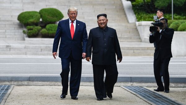 North Korea's leader Kim Jong Un walks with US President Donald Trump - Sputnik Moldova-România