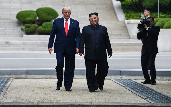 North Korea's leader Kim Jong Un walks with US President Donald Trump - Sputnik Молдова