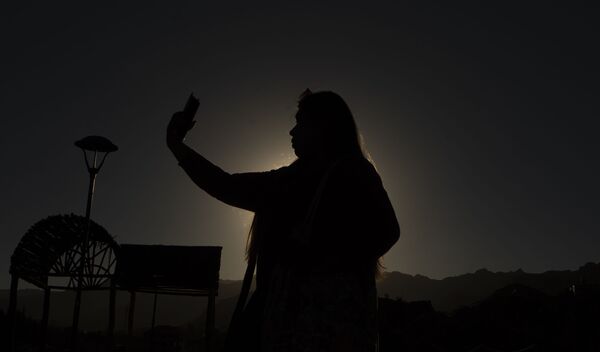 Женщина фотографируется во время солнечного затмения в Боливии - Sputnik Молдова