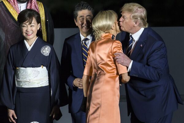 Президент США Дональд Трамп целует первую леди Франции Бриджит Макрон на саммите G20 в Осаке - Sputnik Moldova-România