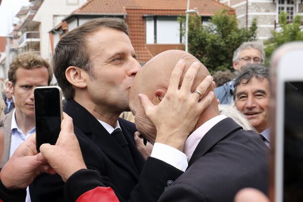 Президент Франции Эммануэль Макрон целует сторонника после голосования на выборы в европарламент в Ле-Туке на севере Франции - Sputnik Moldova-România