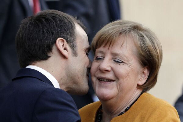 Президент Франции Эммануэль Макрон целует канцлера Германии Ангелу Меркель в Париже - Sputnik Moldova-România
