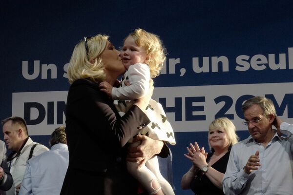 Марин ле Пен целует девочку во время предвыборного митинга в Энен-Бомоне, Франция - Sputnik Moldova-România