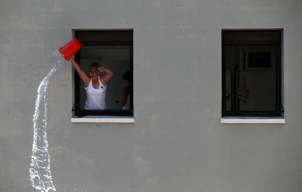Женщина льет воду на участников фестиваля Сан-Ферми в Памплоне, Испания - Sputnik Молдова
