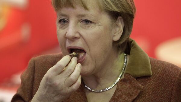 Канцлер Германии Ангела Меркель во время поедания кусочка шоколада  - Sputnik Moldova-România
