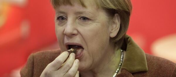 Канцлер Германии Ангела Меркель во время поедания кусочка шоколада  - Sputnik Moldova-România