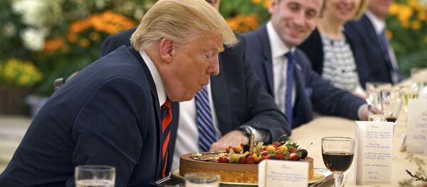 Президент США Дональд Трамп задувает свечу на торте в свой день рождения во время встречи с премьер-министром Сингапура Ли Сянлуном - Sputnik Молдова