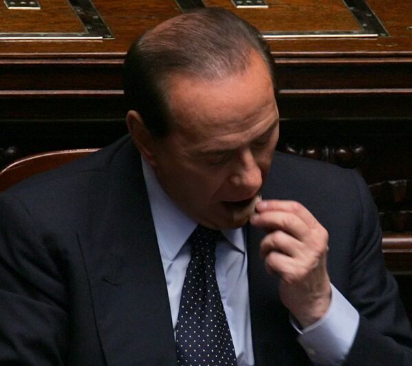 Prim-ministru italian, Silvio Berlusconi, mănâncă o bucată de ciocolată la Roma, în 2005 - Sputnik Moldova