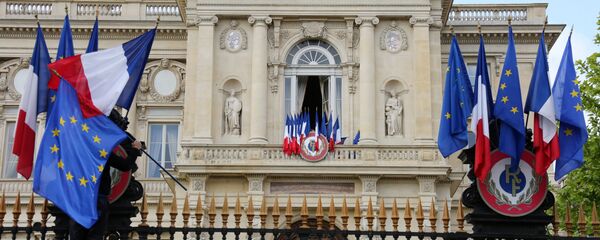 A worker arranges European flags alongside French national flags on the railings outside the Ministry of Foreign Affairs in Paris on May 9, 2015 as part of events marking Europe Day. - Sputnik Moldova