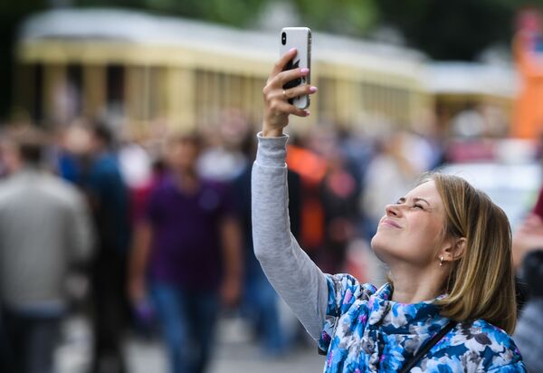 Девушка фотографирует старинные трамвайные вагоны на торжественном параде, приуроченном к празднованию Дня московского транспорта - Sputnik Молдова