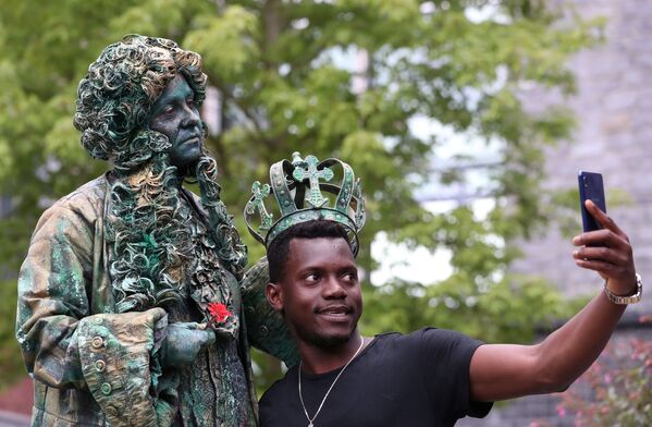 Мужчина фотографируется с участником фестиваля живых статуй в Бельгии  - Sputnik Молдова