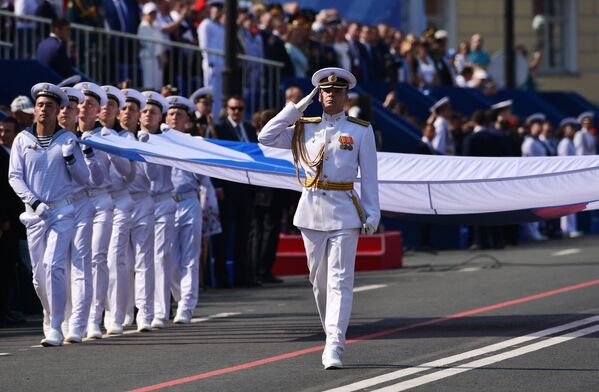 Военнослужащие маршируют с Андреевским флагом на главном военно-морском параде, посвященном Дню ВМФ в Санкт-Петербурге - Sputnik Молдова