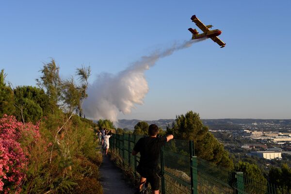Пожарный самолет Canadair сбрасывает воду над огнем, вспыхнувшим в промышленной зоне Витроль на юго-востоке Франции - Sputnik Молдова