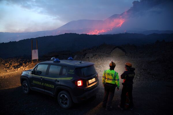 Сотрудники итальянской налоговой полиции наблюдают за извержением вулкана Этна на Сицилии - Sputnik Молдова