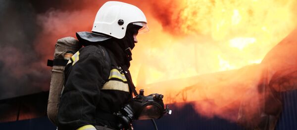 Сотрудник МЧС во время тушения пожара Сотрудник МЧС во время тушения пожара - Sputnik Молдова