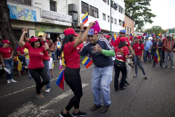 Сторонники венесуэльского правительства танцуют во время протеста против санкций США в Каракасе  - Sputnik Moldova-România