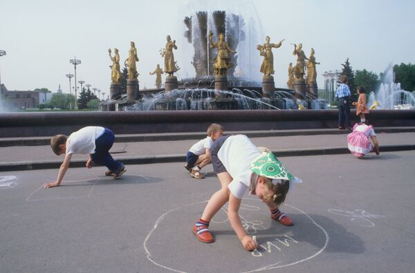 Дети рисуют мелом на асфальте у фонтана Дружба народов в Москве. 1984 - Sputnik Молдова