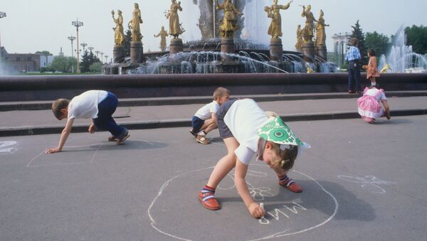 Дети рисуют мелом на асфальте у фонтана Дружба народов в Москве. 1984 - Sputnik Молдова