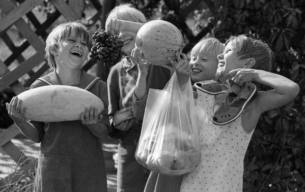 Воспитанники Ташкентского детского дома держат в руках дыню, арбуз, виноград и персики, которые они сами вырастили на своем приусадебном участке, 1983 год - Sputnik Moldova-România
