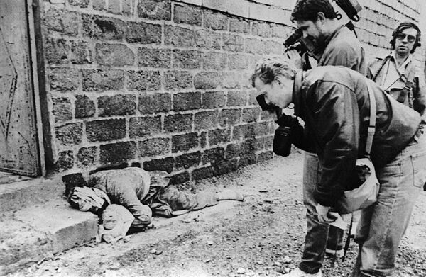 Фотограф и оператор снимают курда с ребенком на руках, погибших в результате химической атаки на город Халабджа, Ирак, 20 марта 1988 года - Sputnik Moldova-România